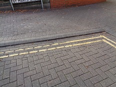 Bevelled kerbing assists wheelchairs.